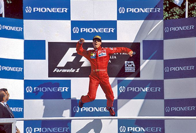 Michael Schumacher springt juichend op het podium van de Grand Prix van Italië